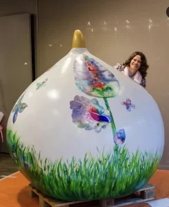 Reuzenbol in de Bollenstreek - medium mary willemsen staat trots lachend achter haar beschilderde reuzenbol