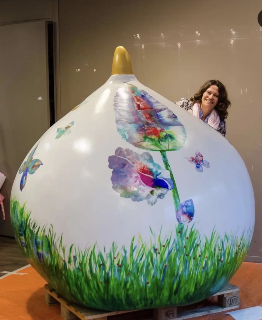 Reuzenbol in de Bollenstreek - medium mary willemsen staat trots lachend achter haar beschilderde reuzenbol